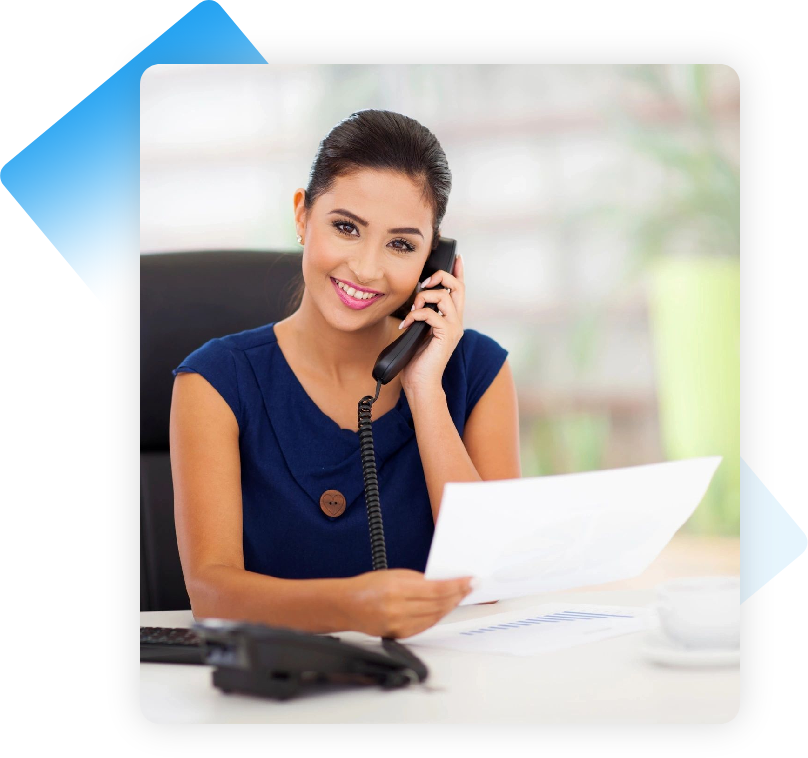 A woman sitting at her desk on the phone